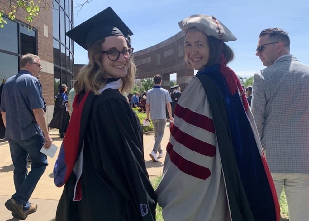Jaenna Willaims and Meredith Hartley looking back at the camera in ceremonial gowns