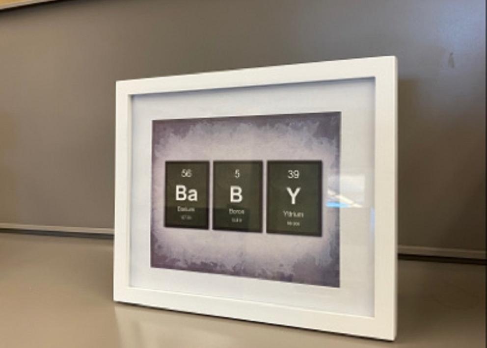 framed picture with a play on the element table spelling out "baby"