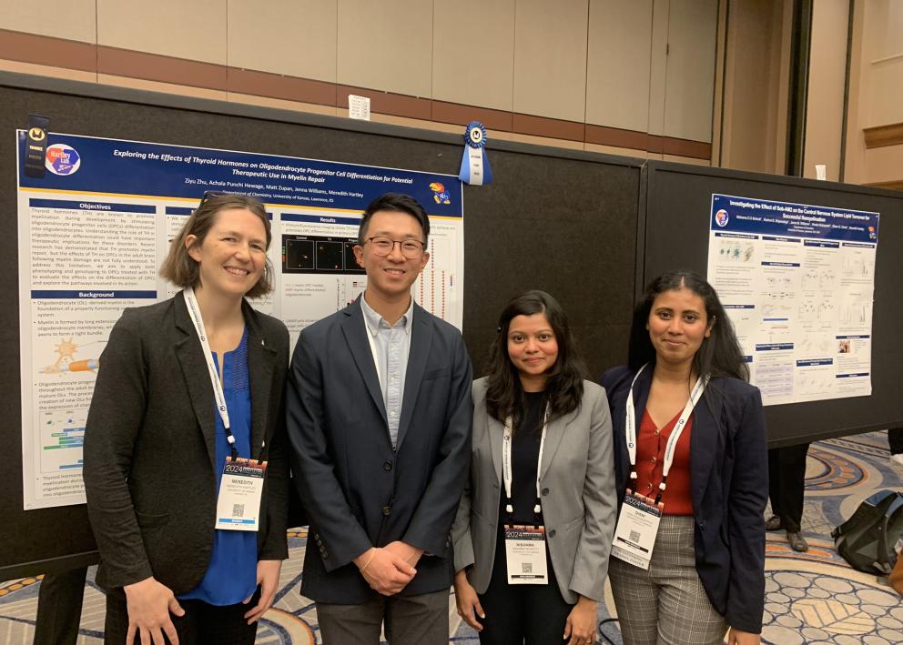 Four people at a poster session