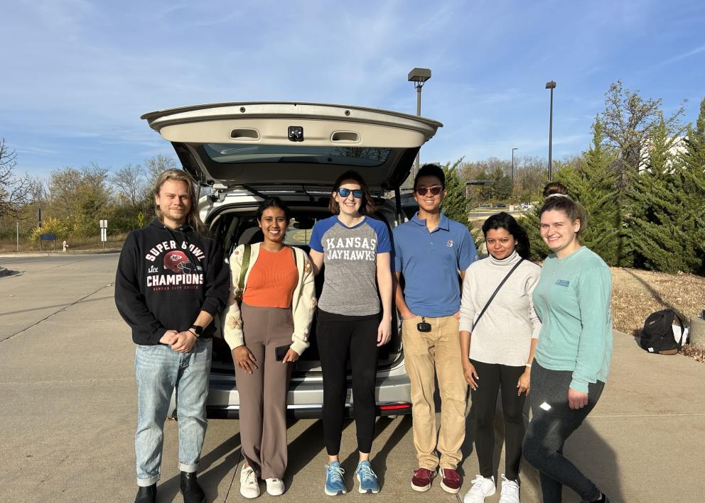 Six people outside in front of a minivan