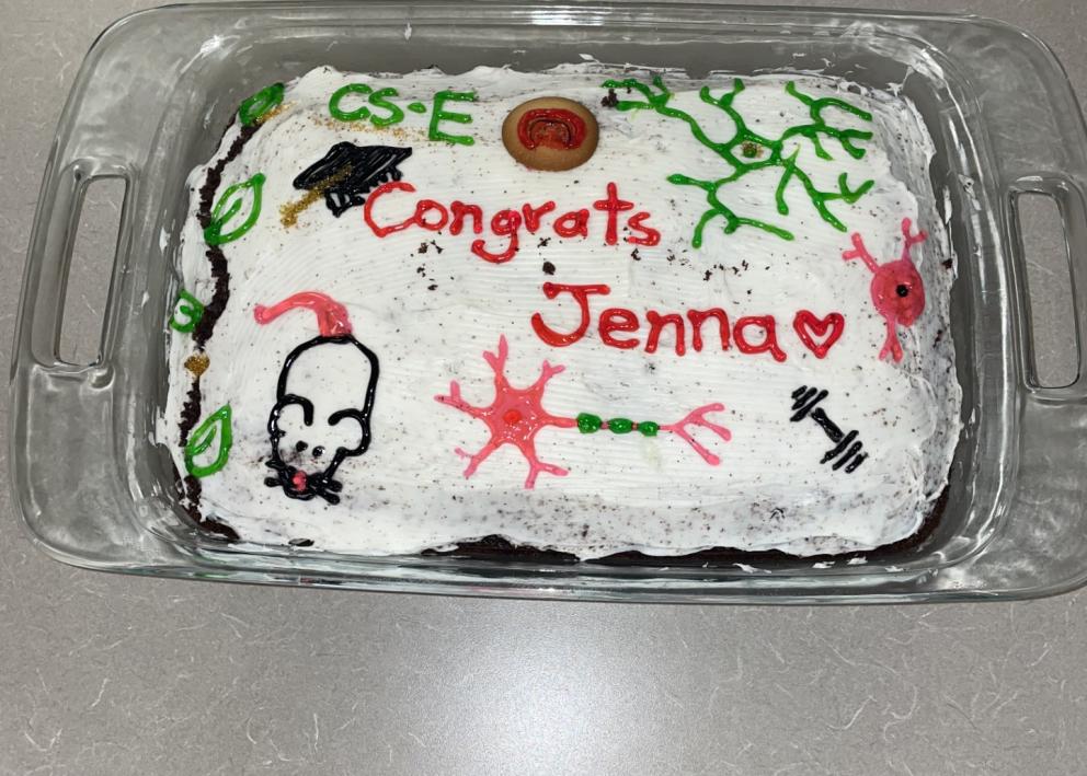 Cake decorated with brain cells that says "Congrats Jenna."