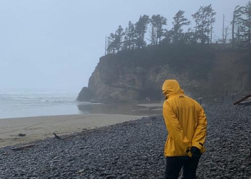 Matt Zupan walking around on a rocky shore by the beach
