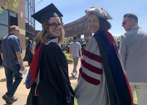 Jaenna Willaims and Meredith Hartley looking back at the camera in ceremonial gowns
