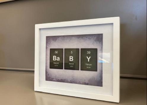 framed picture with a play on the element table spelling out "baby"