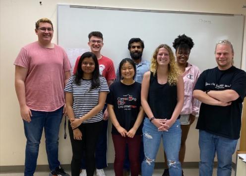 Hartley lab standing together for a picture in a classroom