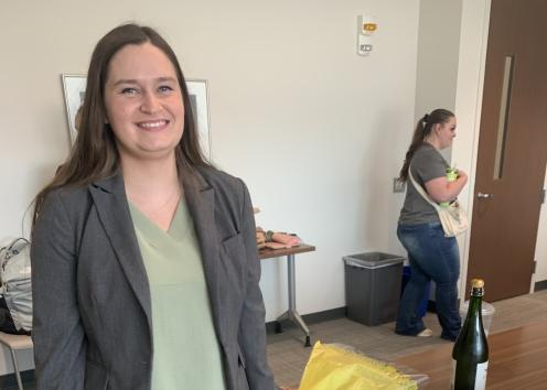 Woman smiles in conference room next to cake
