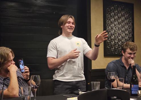 Man stands and give speech at dinner table