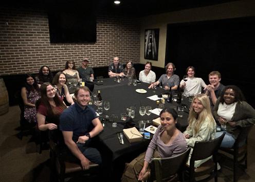 Group of people sit around a square table at a restaurant