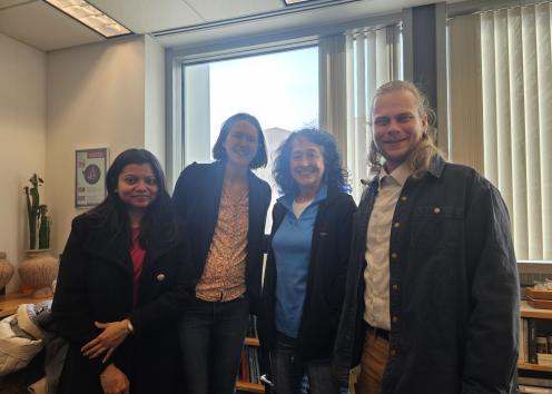 Four people smile in an office 