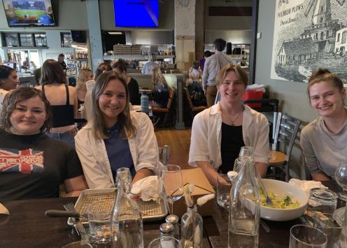 Four people sit at a table in a restaurant