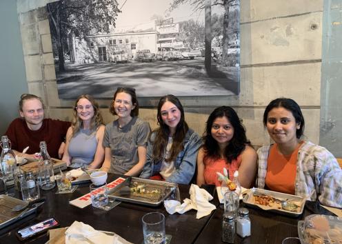 Six people sit at a table in a restaurant
