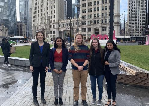 Five people on the street in front of tall buildings in Chicago