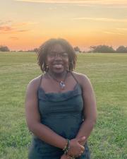 Woman standing in front of sunset